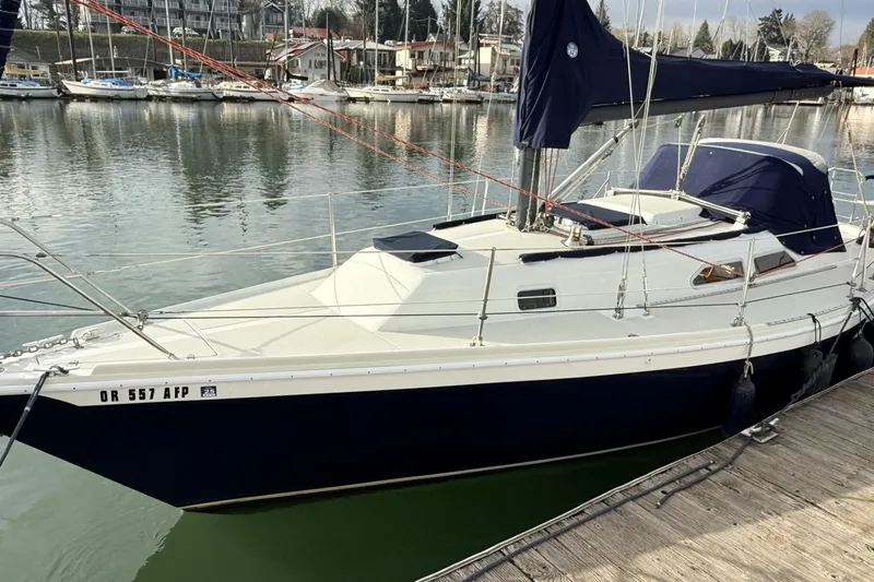 Slide: The Image of 1979 Ericson 30 Plus sailboat docked at a marina, calm water background. - 22