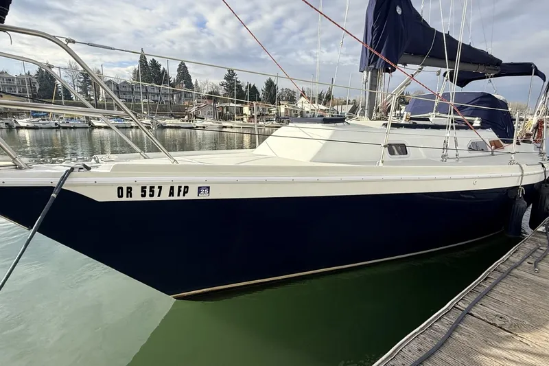 Slide: The Image of 1979 Ericson 30 Plus sailboat docked in a marina, featuring a sleek navy hull. - 24