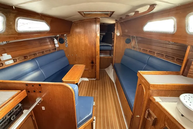 Slide: The Image of Interior of a 1979 Ericson 30 Plus sailboat with wooden finish and blue seating. - 3