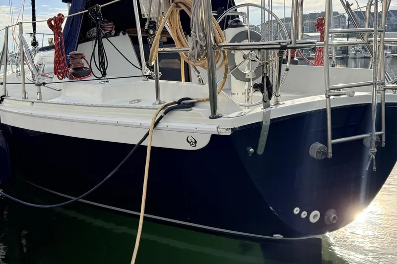 Slide: The Image of 1979 Ericson 30 Plus sailboat docked, featuring a sleek navy and white design. - 39