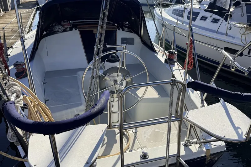 Slide: The Image of 1979 Ericson 30 Plus sailboat cockpit with steering wheel, docked at marina. - 44