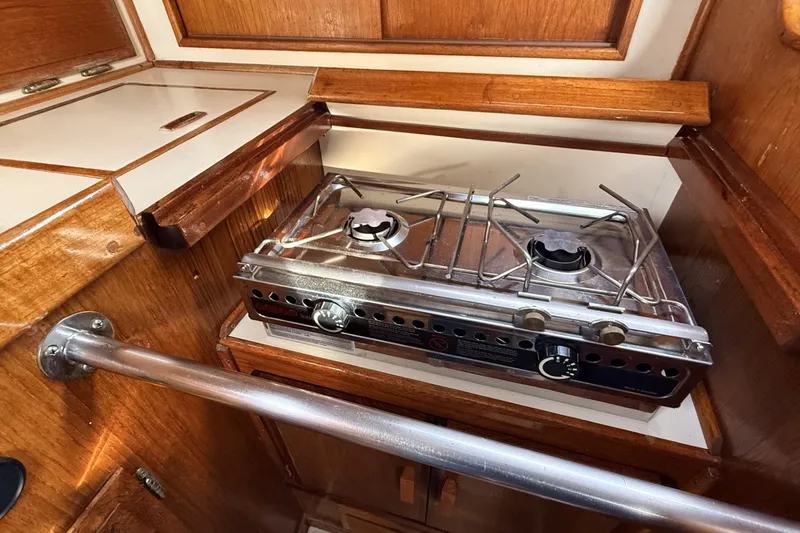 Slide: The Image of 1979 Ericson 30 Plus yacht interior with a compact two-burner stove in a wooden galley. - 8