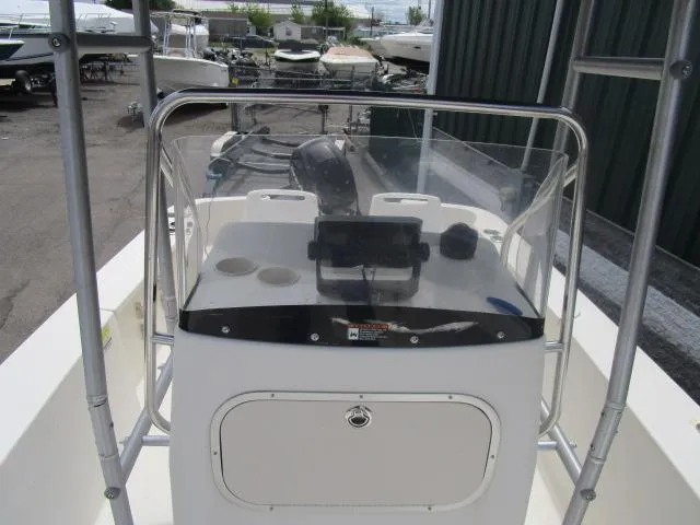 Slide: The Image of 2002 Trophy 1903 CC boat console with windshield and steering wheel in a marina setting. - 11
