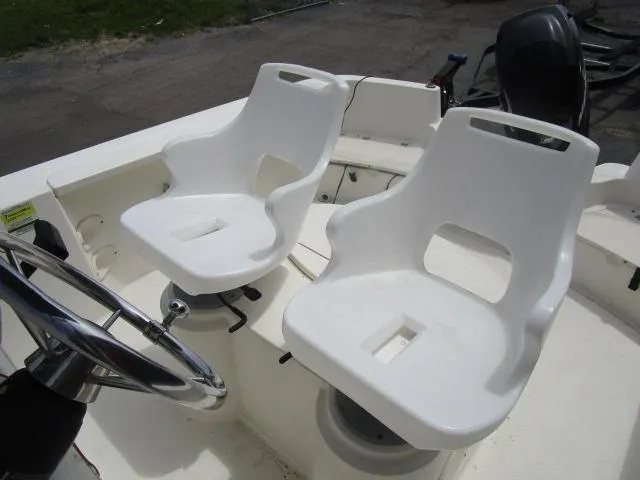 Slide: The Image of Two white boat seats on a 2002 Trophy 1903 CC, with steering wheel visible. - 13