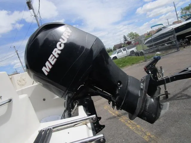 Slide: The Image of Mercury outboard motor on a 2002 Trophy 1903 CC boat, parked outdoors. - 4