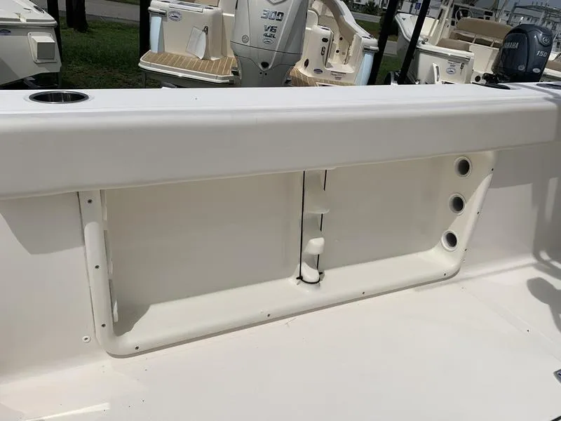 Slide: The Image of 2024 Bulls Bay 255CC boat interior with storage compartment and rod holders. - 11