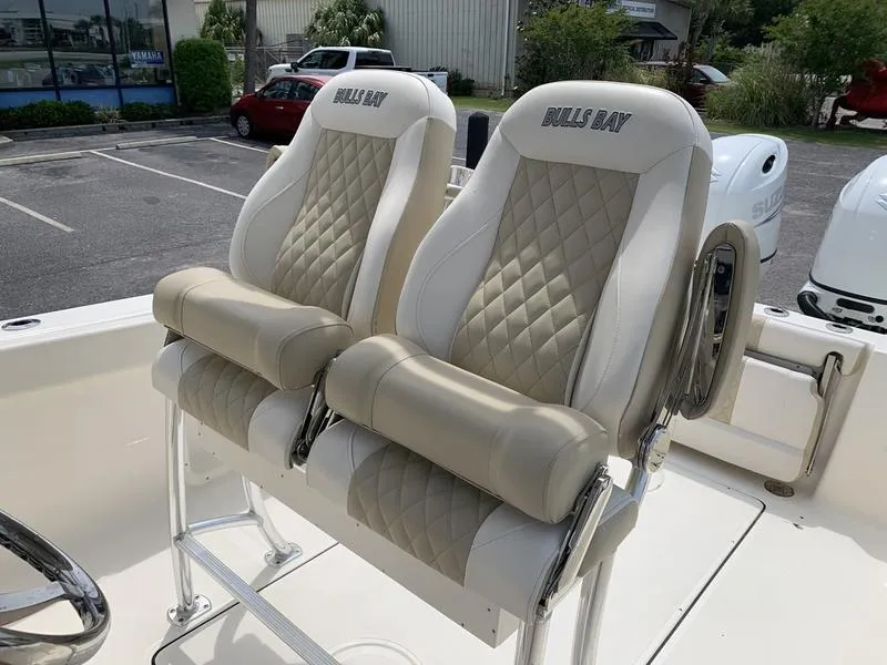 Slide: The Image of 2024 Bulls Bay 255CC boat seats with diamond-pattern upholstery in a parking lot setting. - 15