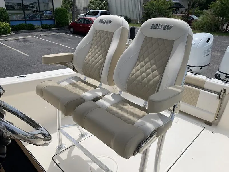 Slide: The Image of 2024 Bulls Bay 255CC boat seats with diamond-pattern upholstery in a parking lot. - 16