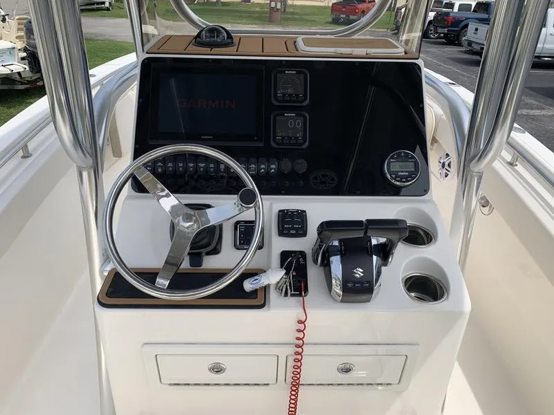 Slide: The Image of 2024 Bulls Bay 255CC boat console with steering wheel, Garmin display, and controls. - 17