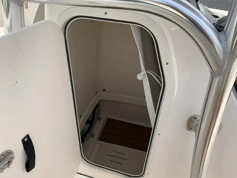 Slide: The Image of 2024 Bulls Bay 255CC boat interior storage compartment with open door. - 23