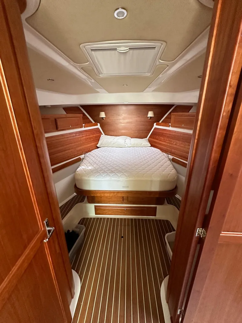 Slide: The Image of 2020 Back Cove 41 yacht cabin with wood paneling and cozy bed. - 15