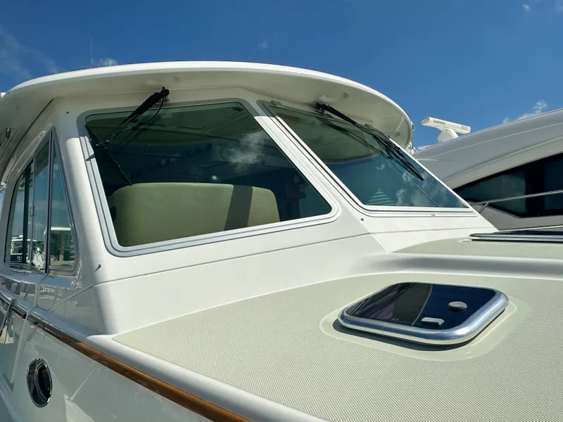 Slide: The Image of 2020 Back Cove 41 yacht, close-up of cabin windows and deck, under clear blue sky. - 24