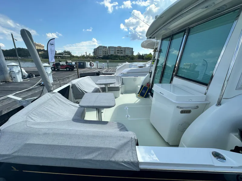 Slide: The Image of 2020 Back Cove 41 yacht with covered seating area and marina view. - 25