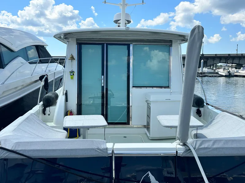 Slide: The Image of 2020 Back Cove 41 yacht docked, featuring a spacious rear deck and sliding glass doors. - 26