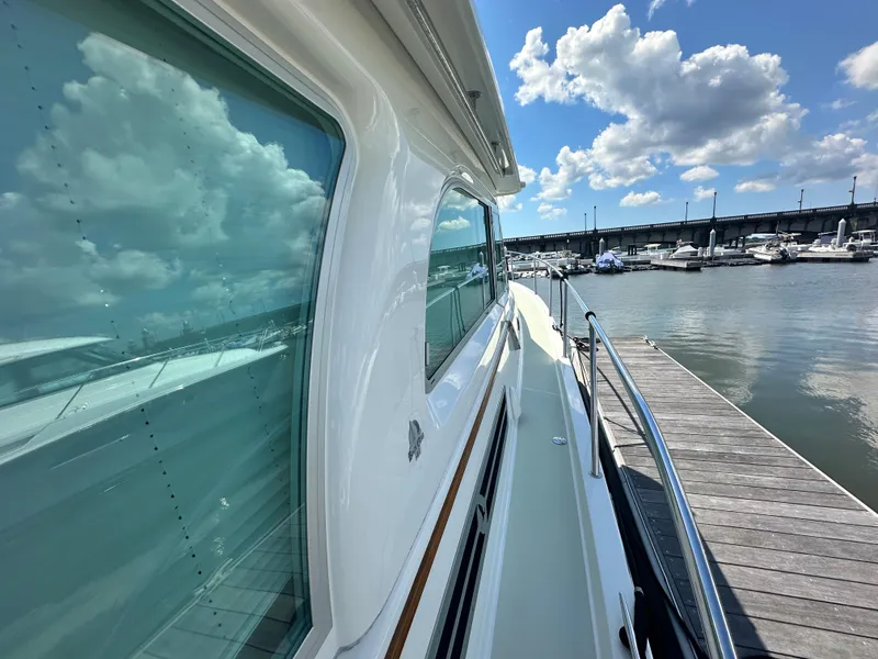 Slide: The Image of Back Cove 41 yacht docked at marina, reflecting blue sky and clouds, 2020 model. - 28