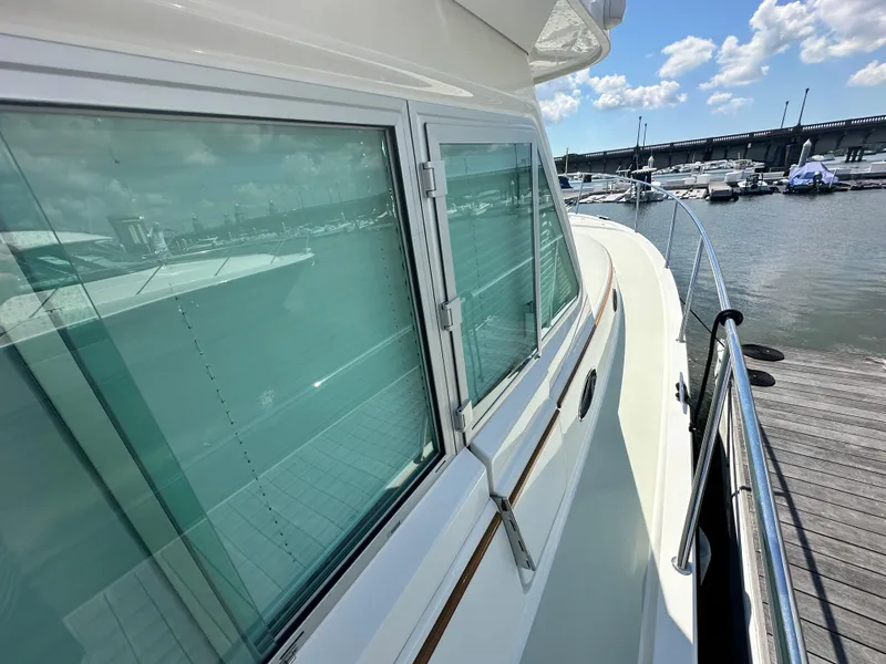 Slide: The Image of 2020 Back Cove 41 yacht docked, showcasing sleek windows and elegant design. - 29