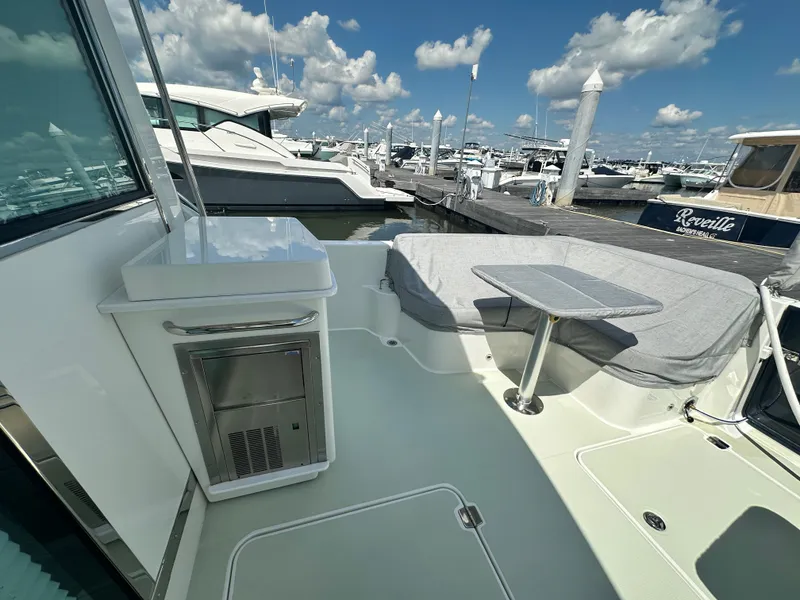 Slide: The Image of 2020 Back Cove 41 yacht deck with seating and table, docked at marina. - 49
