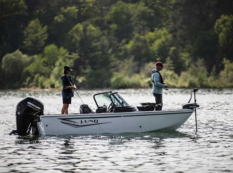Slide: The Image of 2026 Lund 1650 Rebel XL SS boat with two people fishing on a lake. - 0