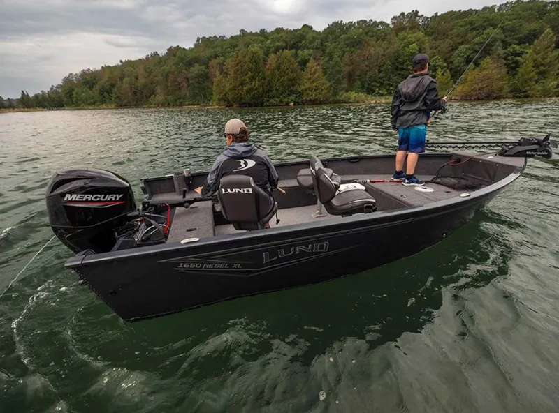 Slide: The Image of 2026 Lund 1650 Rebel XL SS boat on a lake with two people fishing. - 1