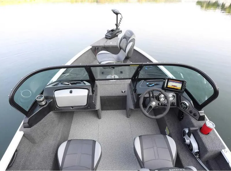 Slide: The Image of 2026 Lund 1650 Rebel XL SS boat interior with steering wheel, seats, and control panel. - 2