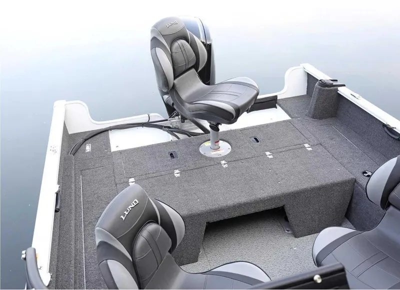 Slide: The Image of 2026 Lund 1650 Rebel XL SS boat interior with swivel seats and gray carpeting. - 6