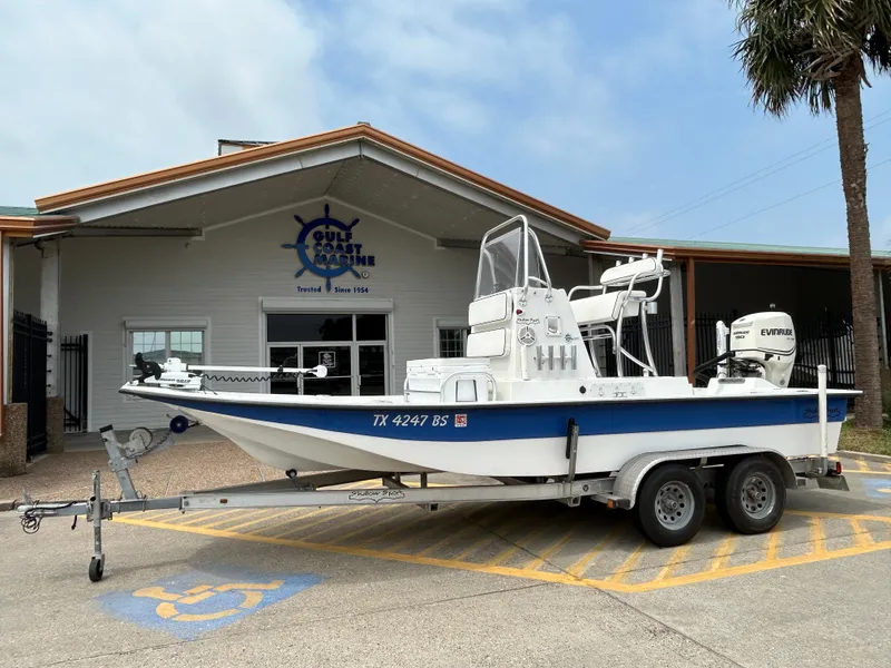 Slide: The Image of 2012 Shallow Sport 21 Sport boat on trailer outside Gulf Coast Marine building. - 1
