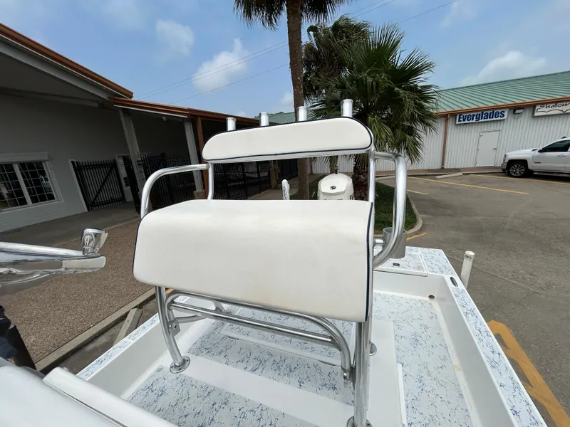 Slide: The Image of 2012 Shallow Sport 21 Sport boat with white seating, parked near a building and palm tree. - 11