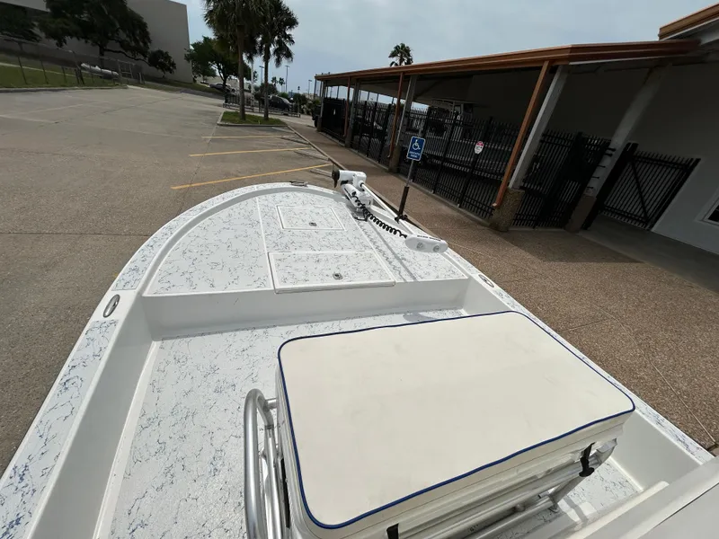 Slide: The Image of 2012 Shallow Sport 21 Sport boat parked, featuring spacious deck and seating. - 12