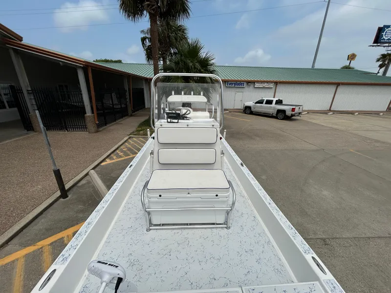 Slide: The Image of 2012 Shallow Sport 21 Sport boat parked in a lot, showcasing seating and console. - 13