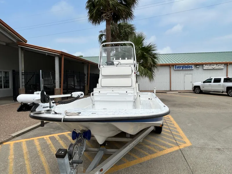 Slide: The Image of 2012 Shallow Sport 21 Sport boat on trailer, parked near palm tree and building. - 3