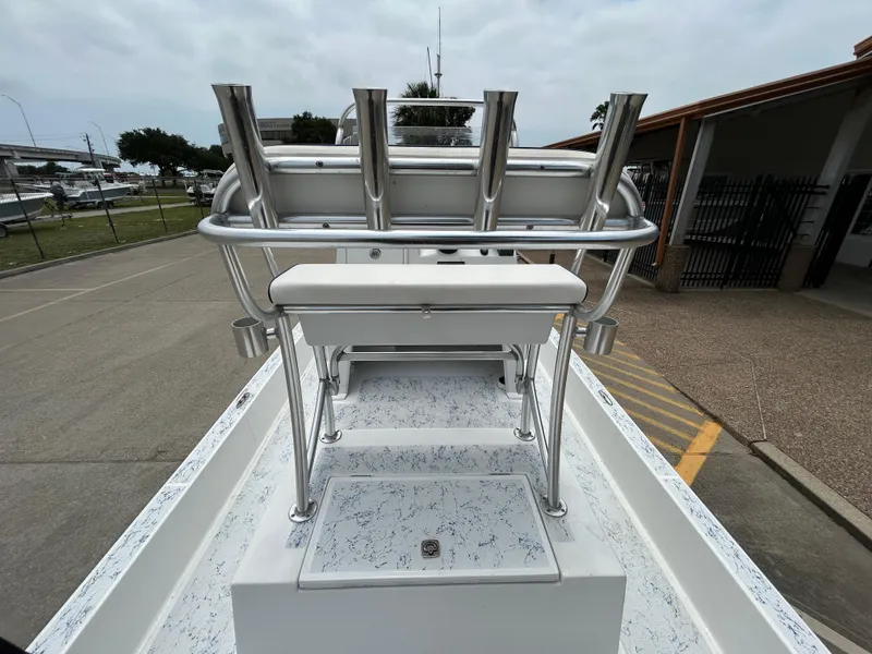 Slide: The Image of 2012 Shallow Sport 21 Sport boat with rod holders and seating, parked outdoors. - 7
