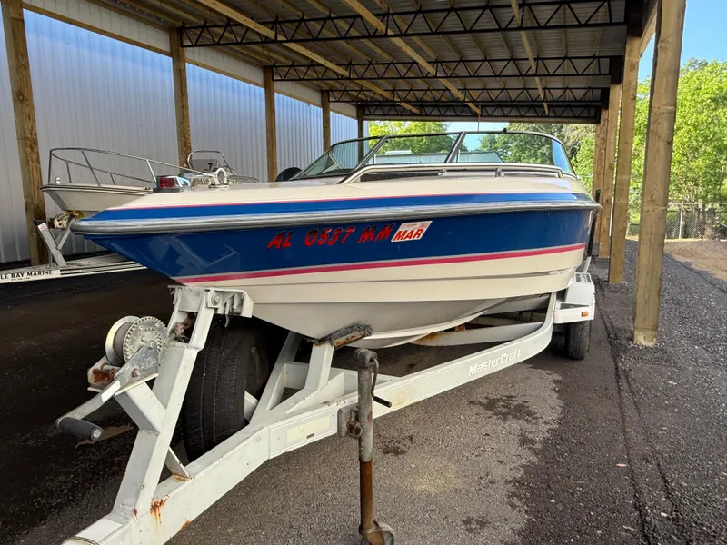 The Image of 1994 MasterCraft MARISTAR 225 VRS boat on trailer under a covered storage area. - 1
