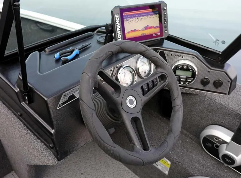 Slide: The Image of 2026 Lund 1650 Rebel XL SS boat dashboard with steering wheel and navigation display. - 3