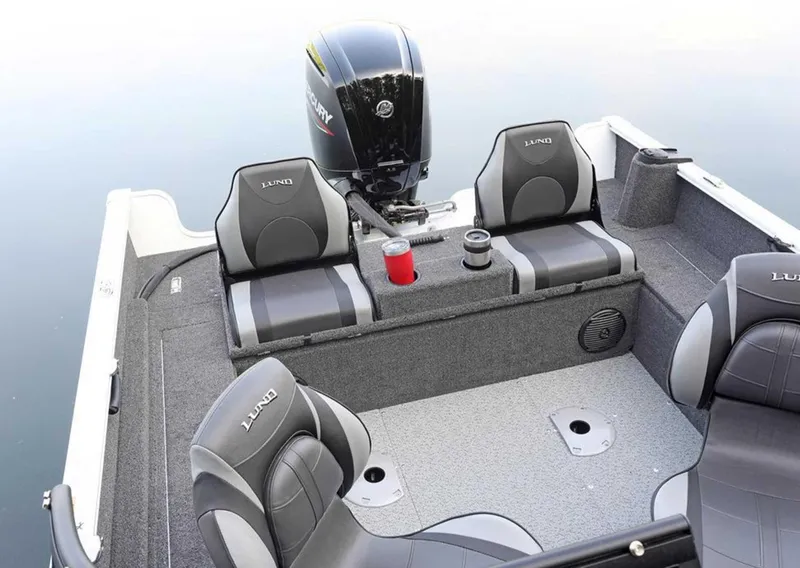 Slide: The Image of 2026 Lund 1650 Rebel XL SS boat interior with seating and motor on calm water. - 5