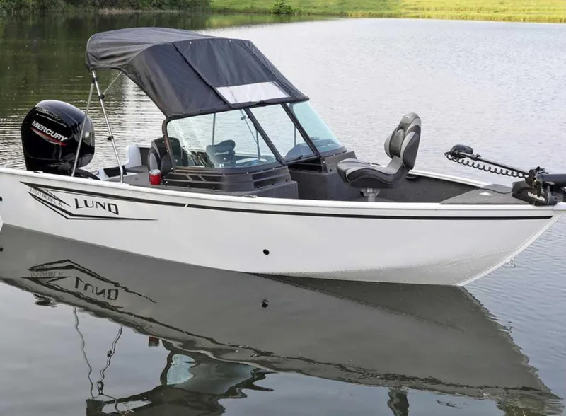 Slide: The Image of 2026 Lund 1650 Rebel XL SS boat on calm water, featuring a sleek design and canopy. - 7
