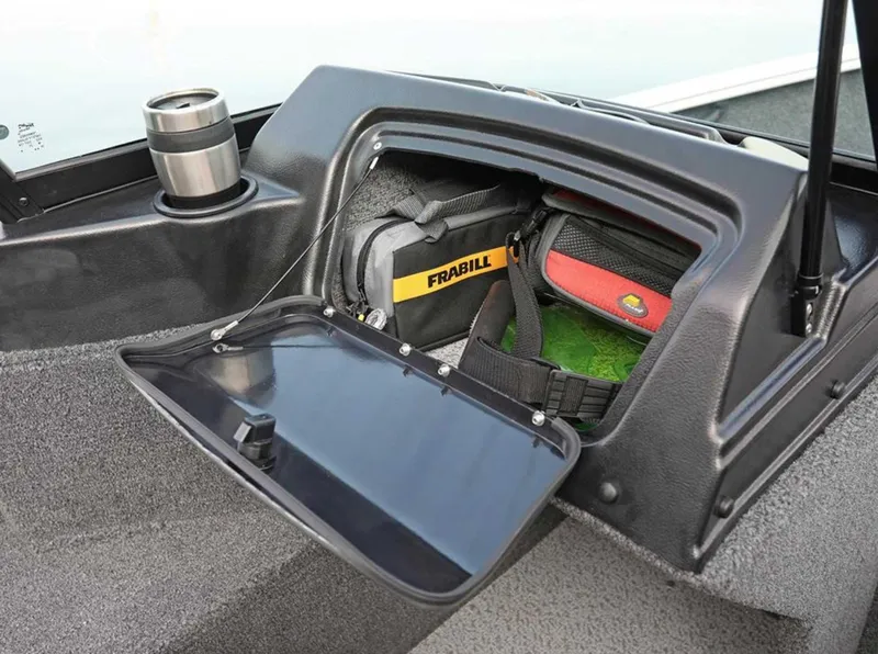 Slide: The Image of 2026 Lund 1650 Rebel XL SS storage compartment with gear and cup holder. - 4