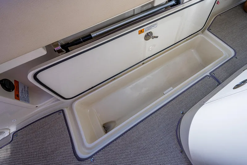 Slide: The Image of 2019 Chris-Craft Catalina 27 storage compartment with open lid, showcasing spacious interior. - 27