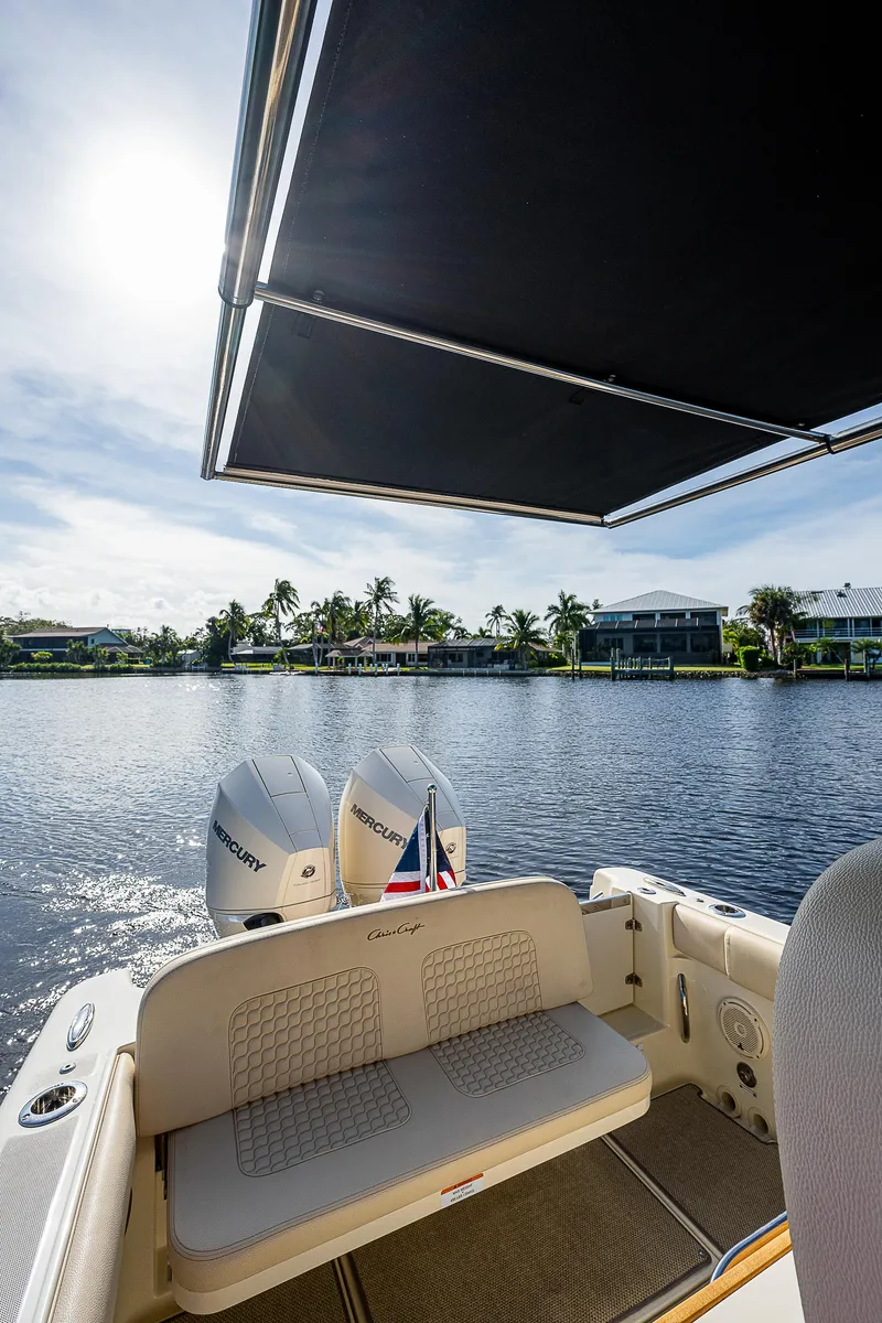 Slide: The Image of 2019 Chris-Craft Catalina 27 boat with dual Mercury engines on a sunny waterfront. - 31
