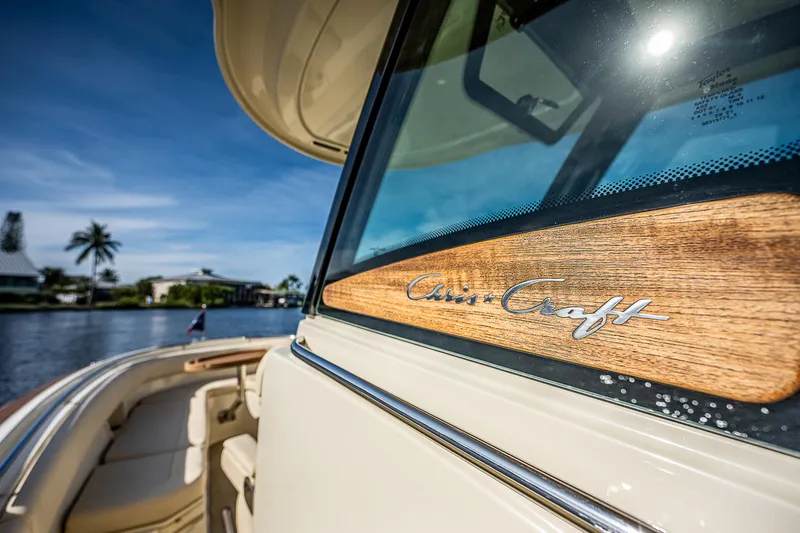 Slide: The Image of 2019 Chris-Craft Catalina 27 boat with wooden trim, docked by a scenic waterfront. - 39