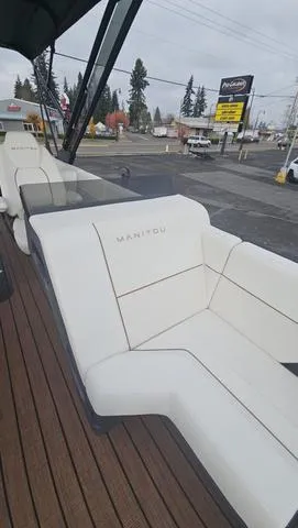 Slide: The Image of 2025 Manitou 24 EXPLORE DUAL MOTOR NAVIGATOR with white seating and wooden deck. - 19