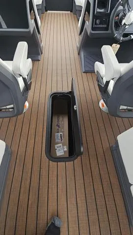 Slide: The Image of 2025 Manitou 24 EXPLORE DUAL MOTOR NAVIGATOR interior with open storage compartment. - 28