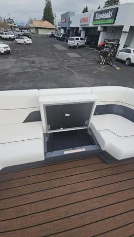 Slide: The Image of 2025 Manitou 24 Explore Dual Motor Navigator boat with white seating, displayed at a dealership. - 5