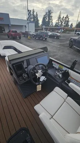 Slide: The Image of 2025 Manitou 24 EXPLORE DUAL MOTOR NAVIGATOR boat interior with steering wheel and seating. - 9