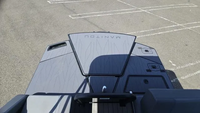 Slide: The Image of 2025 Manitou Explore 24 Max Deck Navigator, sleek design, parked on asphalt. - 13