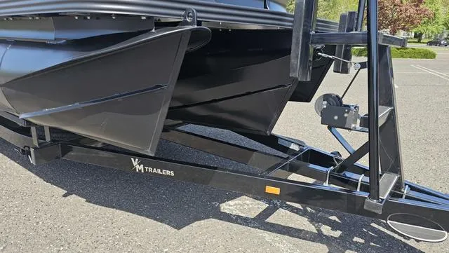 Slide: The Image of 2025 Manitou Explore 24 Max Deck Navigator on VM trailer, parked outdoors. - 16