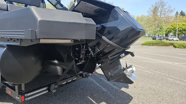 Slide: The Image of 2025 Manitou Explore 24 Max Deck Navigator boat engine in a parking lot. - 5