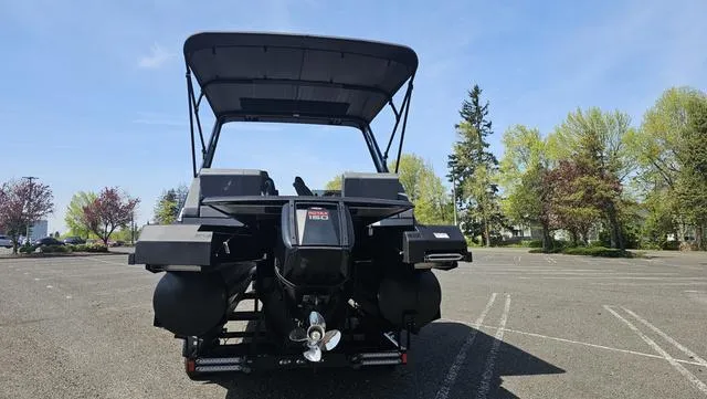 Slide: The Image of 2025 Manitou Explore 24 Max Deck Navigator boat in parking lot, rear view. - 6