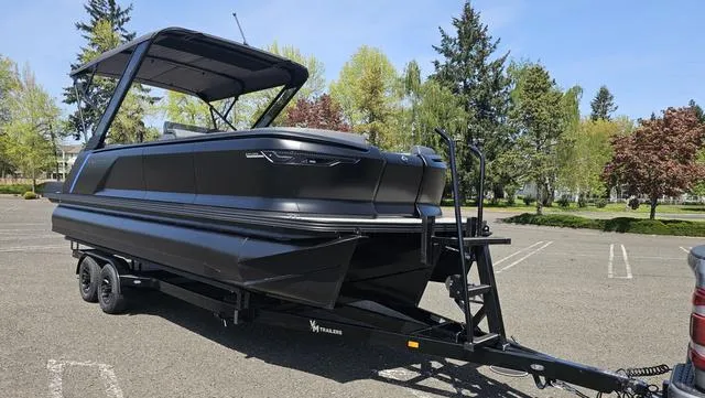 Slide: The Image of 2025 Manitou Explore 24 Max Deck Navigator boat on trailer in parking lot. - 7