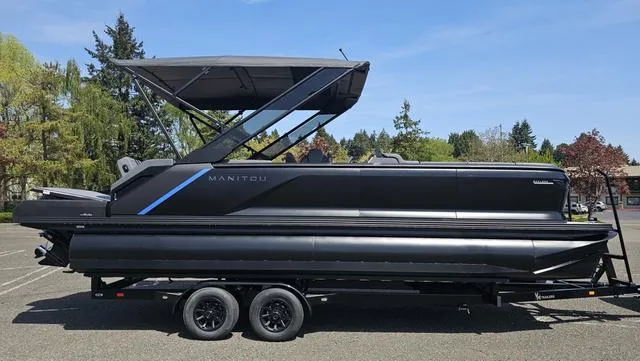 Slide: The Image of 2025 Manitou Explore 24 Max Deck Navigator pontoon boat on trailer, side view. - 8