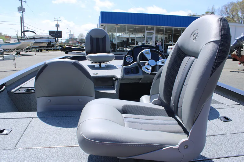 Slide: The Image of 2025 G3 Sportsman 1610 boat interior with gray seating and steering console. - 12